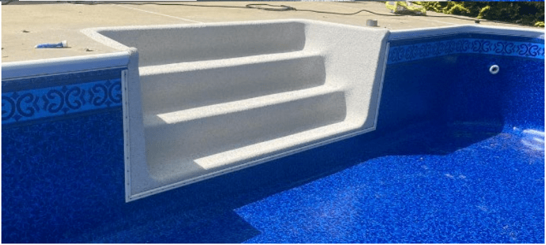 A blue swimming pool featuring steps